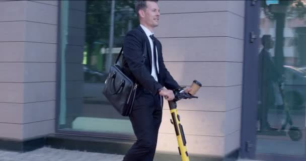 사업 회의에서 전기 스쿠터를 탈 줄아는 사업가. 도시의 거리에서 — 비디오