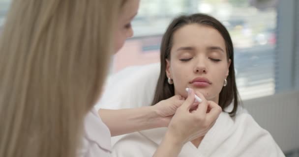 Loira cosmetologist feminino fazer marcas no rosto antes de fazer injeções de beleza — Vídeo de Stock