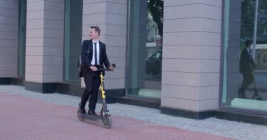 modern iş adamı şehirde işe giderken elektrikli scooter kullanıyor.