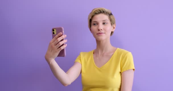 穿着黄色T恤的漂亮的高加索女人，在网上通过电话交谈 — 图库视频影像