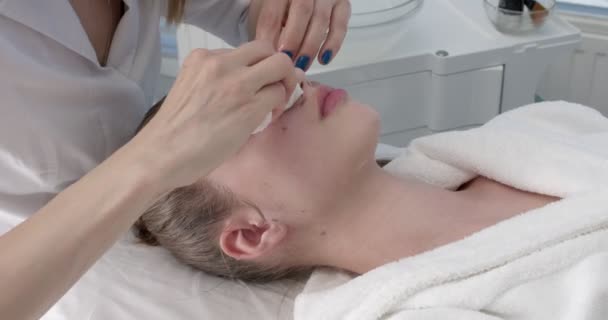 Wellness Schönheitsbehandlung und Hautpflege. Kosmetologe entfernt Gesichtsmaske aus dem Gesicht des Kunden — Stockvideo