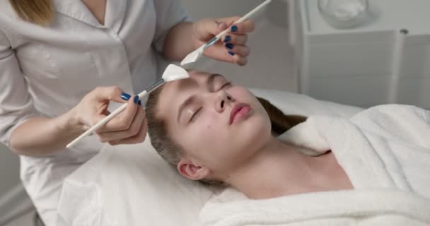 Zblízka boční pohled na atraktivní mladá žena ležící se zavřenýma očima v lázeňském salonu — Stock video
