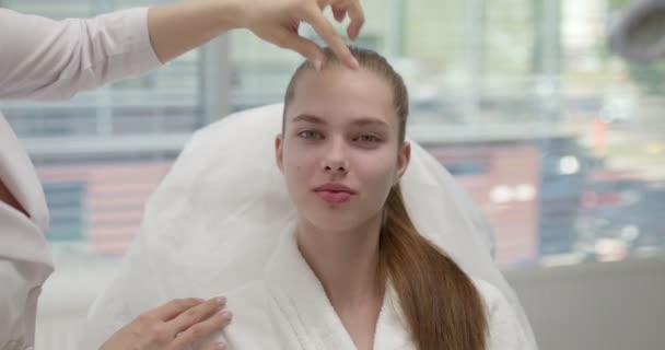 Mujer esteticista mirando sereno joven cara femenina comprobar la condición de la piel — Vídeo de stock