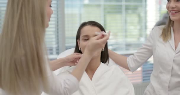 美容治療の結果。美容師は若い患者の顔に輪郭を描く — ストック動画
