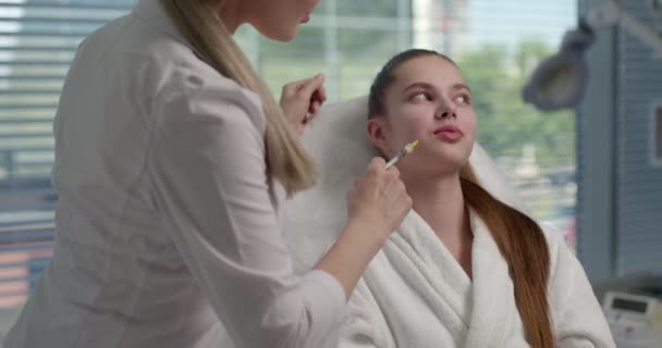 Il cosmetologo fa iniezioni antirughe ringiovanenti su faccia di bella donna — Video Stock