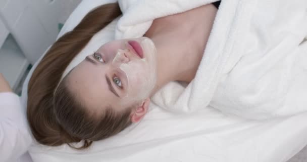 Cilt bakımı ve vücut bakımı, güzellik salonundaki genç beyaz kadın için yüz maskesi. — Stok video