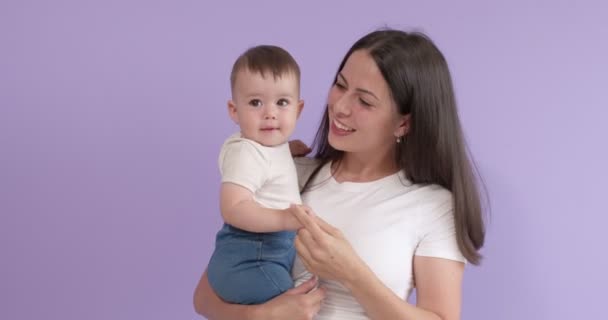 Fiatal barna nő anya gazdaság kisgyermek lány gyermek a kezében, élvezze anyaság — Stock videók