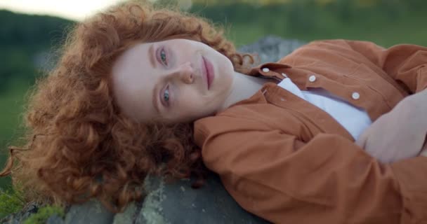Tatlı kızıl saçlı kadın dağın tepesinde tek başına dinleniyor. — Stok video