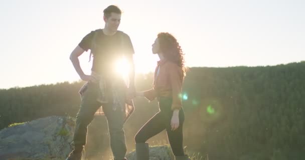 Adorable mujer y hombre de pie abrazándose en las montañas al atardecer en la noche — Vídeo de stock