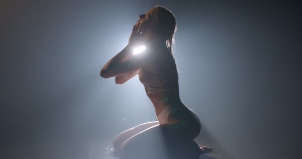 Hubená žena silueta tělo sedí na podlaze ve vlhkém vodním studiu v mlhavém kouřovém prostoru — Stock video