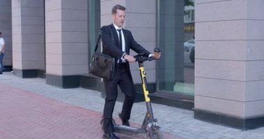 Şehirde elektrikli scooter kullanan yorgun işadamı. Ekoloji kavramı