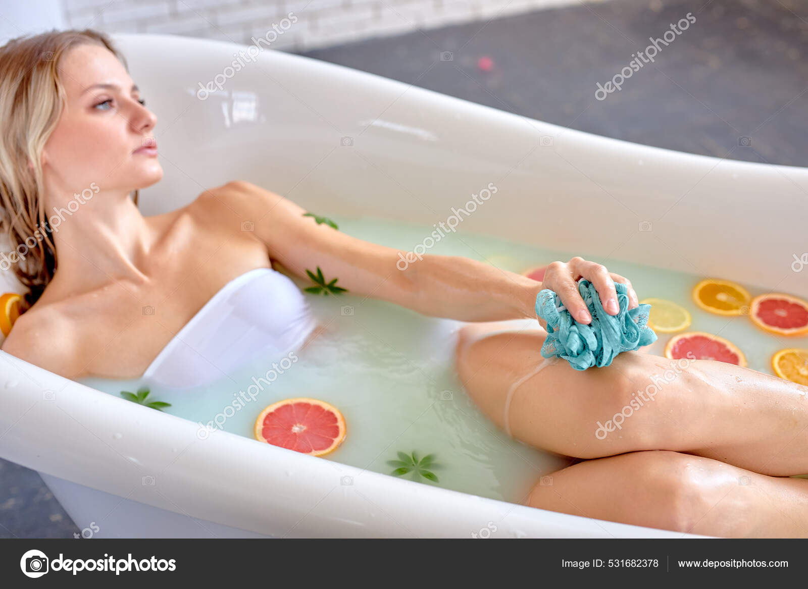 Beautiful sexy woman take bath. benefits of milk baths with flowers and  fruits for skin Stock Photo by ©romanchazov27 531682378