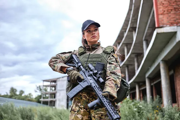 Charmante dame militaire confiante avec arme en forêt, femme en costume de camouflage — Photo