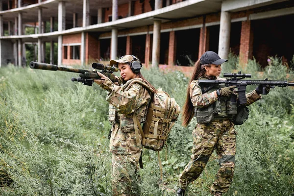 Femmes militaires en équipement tactique posant pour la photo sur le terrain à la saison estivale. — Photo