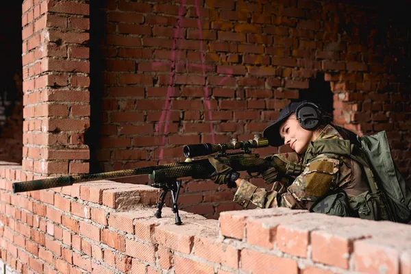 Jeune femme caucasienne avec fusil de sniper avec vue télescopique, garder la défense — Photo