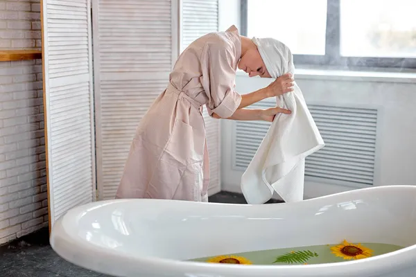 Belle femme caucasienne enveloppe les cheveux dans une serviette après avoir pris un bain — Photo