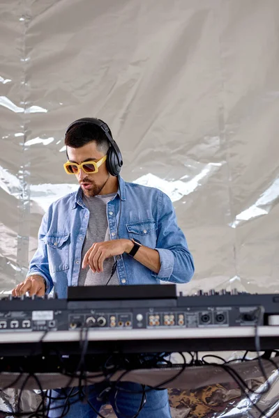 Ung man DJ spela musik i studio, kaukasier man i casual wear utföra klubbmusik — Stockfoto