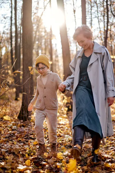 Sevimli çocuk ve anne sıcak sonbahar mevsiminde parkta birlikte vakit geçiriyorlar. — Stok fotoğraf