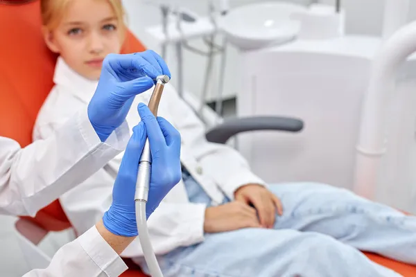 Υγιή δόντια και χαμόγελο. Cropepd γιατρός κάθεται στην οδοντιατρική καρέκλα, κρατώντας οδοντιατρική άσκηση στο χέρι — Φωτογραφία Αρχείου