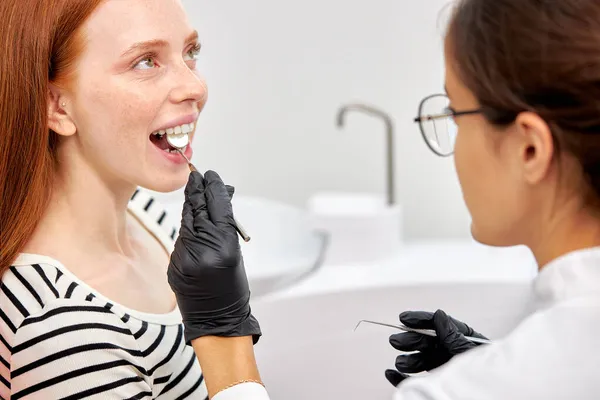 Η χαρούμενη κοκκινομάλλα εξετάζεται από τον οδοντίατρο στην οδοντιατρική κλινική.. — Φωτογραφία Αρχείου