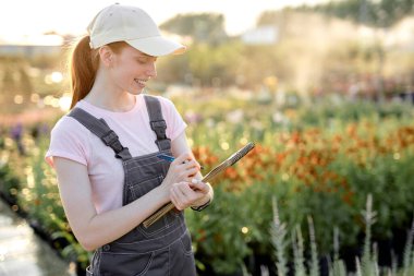Serada çalışan, üzerinde not defteri olan, üniformalı, kızıl saçlı bir kadın araştırmacı.