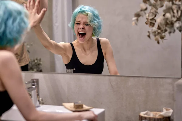 Kvinna känslomässigt skrikande nära badrumsspegeln, har stress, problem — Stockfoto