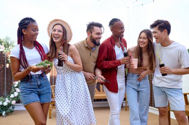 Mutlu arkadaşlar limonata içerek, konuşarak eğleniyorlar. Milenyum halkı eğleniyor