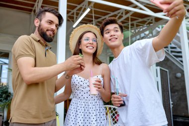 Irklar arası grup arka bahçede Patty 'nin keyfini çıkarıyor, akıllı telefondan neşeyle fotoğraf çekiyorlar.