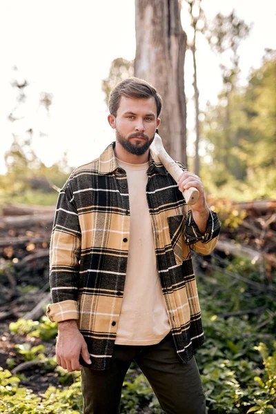 Un leñador seguro trabaja en el bosque de verano. Lumberjack con un hacha en la noche. — Foto de Stock