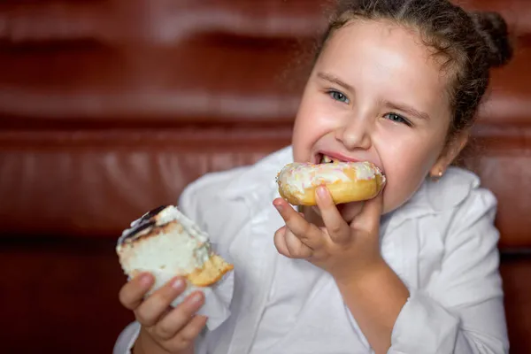 Grasso ragazza si sente fame e mangiare dolce snack torta mentre seduto sul pavimento guardando la tv — Foto Stock