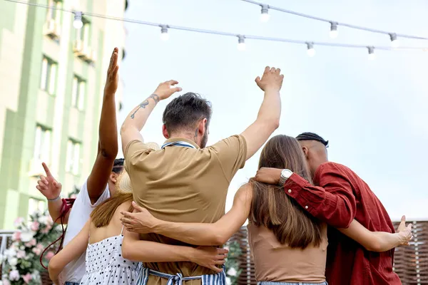 Pessoas felizes alegres que fazem festa ao ar livre, levantando a mão para cima celebrando, vista das costas — Fotografia de Stock