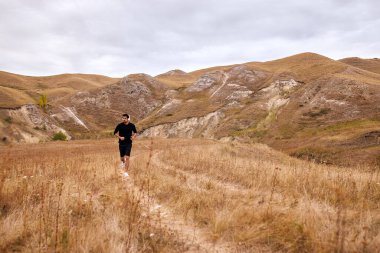 Koşu sporu. Sunsetrise 'de sahada koşan bir adam. Erkek sporcu modeli.