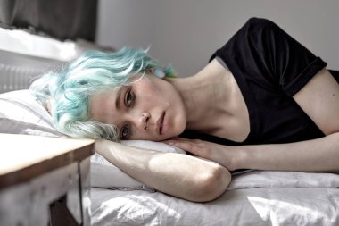 İşle ya da ilişkilerle ilgili sorunları olan üzgün bir kadın. Yatakta yalan söylüyor.