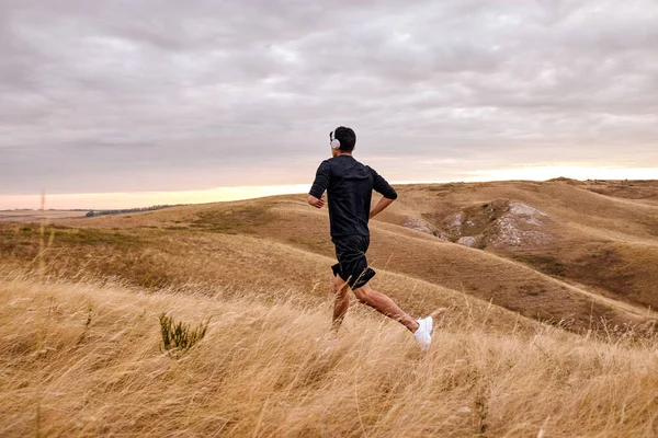 Männerläufertraining. Männliche Sportler führen gesunden Lebensstil beim Joggen im Feld an — Stockfoto