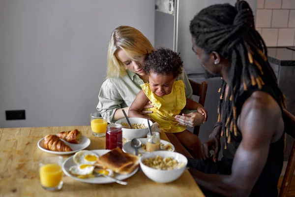 Χαριτωμένο παιδί κλαίει ενώ παίρνει πρωινό με τους γονείς, άτακτη κόρη — Φωτογραφία Αρχείου