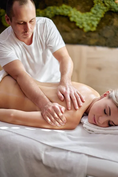 Задній хребет кавказької молодої жінки, що має масаж ароматерапії ефірною олією — стокове фото