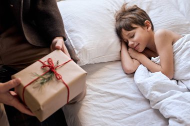 Sevgili oğlum için Noel sürprizi. Babasından hediye paketi alan çocuk.