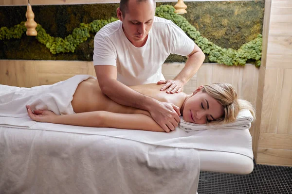 Masaje y cuidado corporal. Mujer joven con piel bronceada o miel recibiendo masajes relajantes —  Fotos de Stock