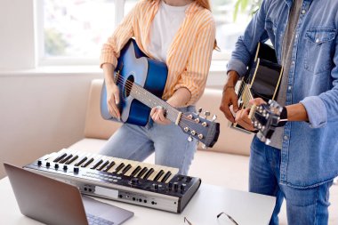 Kırpılmış beyaz adam, kız arkadaşıyla birlikte gitar çalıp şarkı söylüyor.