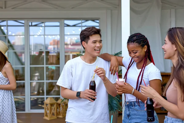 Güzel, mutlu, çeşitli arkadaşlar konuşuyor. Evin terasında eğleniyorlar.