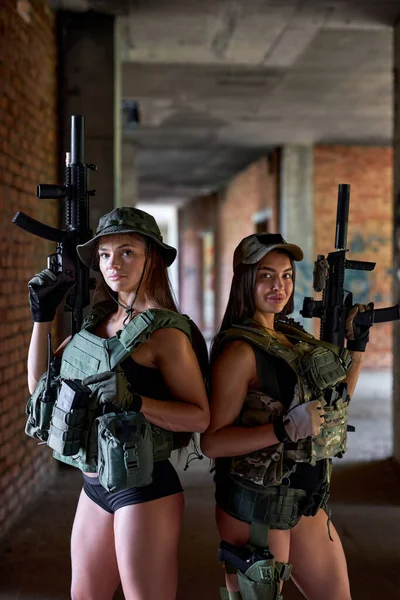 Equipo de soldados militares femeninos en municiones de engranaje posando en cámara con armas — Foto de Stock