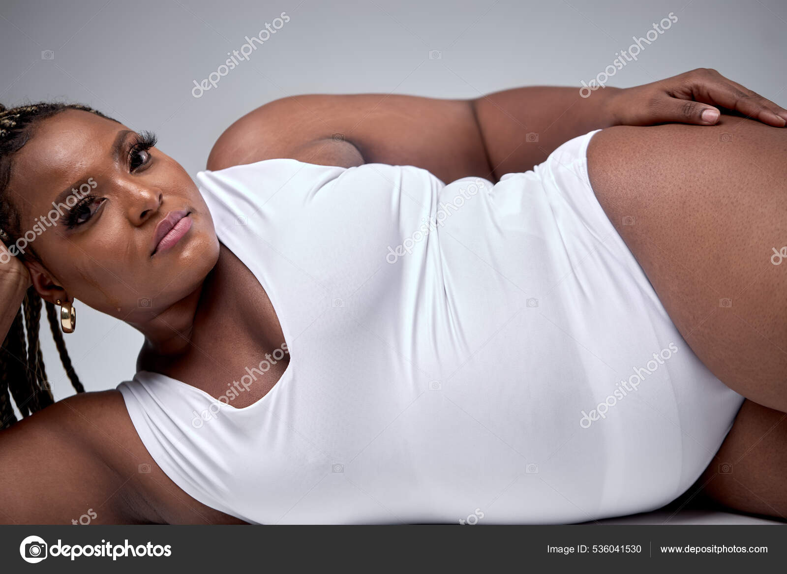 Adorável jovem sexy mulher gorda em branco bodysuit está deitado, tocando  suave pele sedosa fotos, imagens de © romanchazov27 #536041530