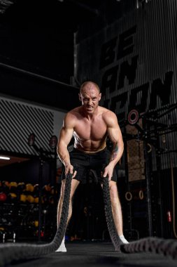 Spor. Savaş halatları seansı. Çekici genç formda sporcu spor yapıyor.