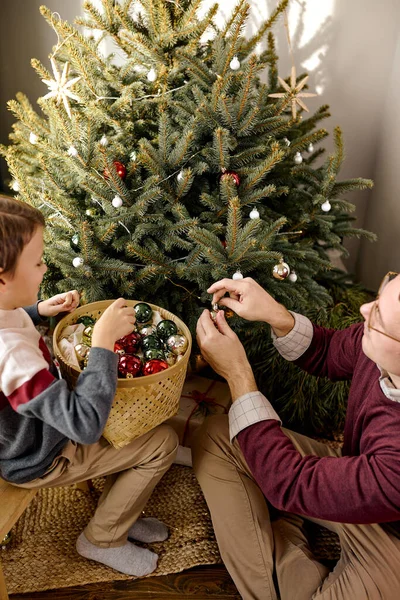 Baba ve oğul Noel arifesinde birlikte Noel ağacı süslüyorlar. aile kavramı — Stok fotoğraf