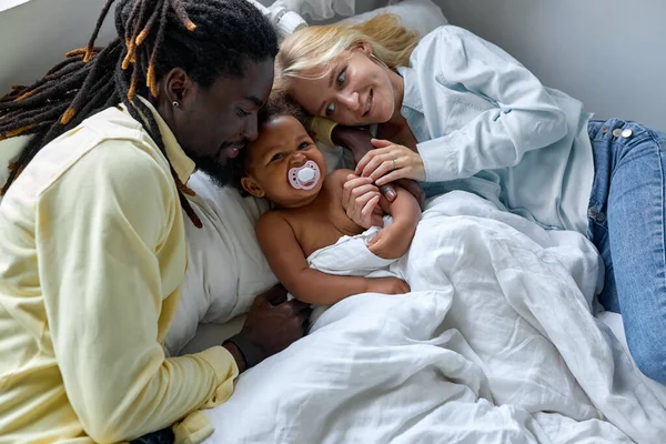 Hermosa familia multiétnica, los padres negros y caucásicos se divierten con su hija — Foto de Stock