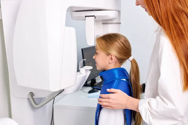Kvinna tandläkare som tar tänder röntgen av barn patient med hjälp av modern tandläkarutrustning. — Stockfoto