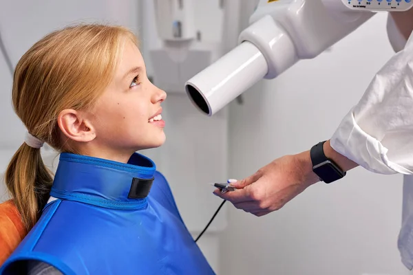 Усміхнена дівчина-пацієнт збирається зробити панорамний рентген зубів в стоматологічній клініці — стокове фото