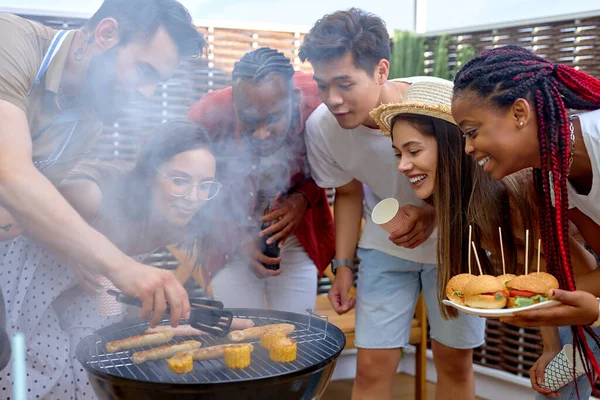 Izgarada yemek yapan bir grup genç öğrenci, piknikte çeşitli insanlar. — Stok fotoğraf