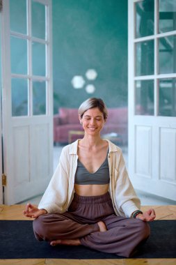 Spor salonundaki spor minderinde oturan mutlu genç bayan. Bayan Egzersiz Yapıyor.