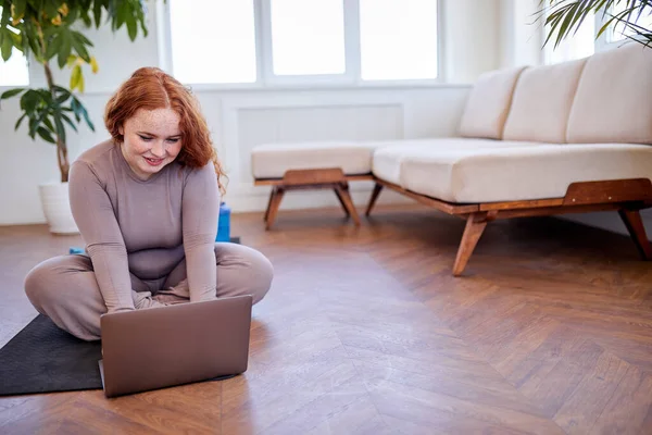 Tombul gülümseyen kadın, online kişisel antrenörden ders bekliyor, dizüstü bilgisayar kullanıyor. — Stok fotoğraf